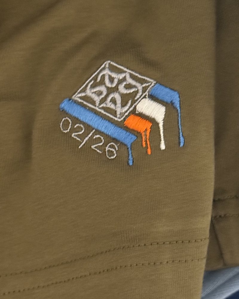 Embroidered numbered logo near the hem